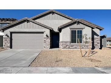 Charming single-story home with a two-car garage, stone accents, neutral stucco, and manicured landscaping at 23284 W Miami St, Buckeye, AZ 85326