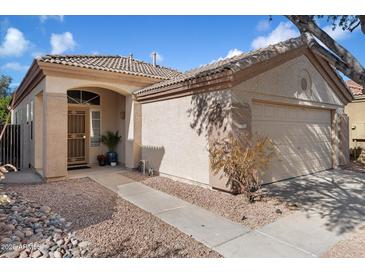 Charming single-story home featuring a tile roof, arched entry, and a two-car garage for convenient parking and curb appeal at 30420 N 43Rd St, Cave Creek, AZ 85331