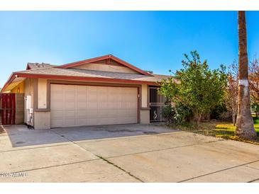 Beige single-story house with an attached two-car garage and desert landscaping at 3135 W Echo Ln, Phoenix, AZ 85051