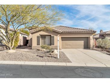 Charming single-story home with a desert landscape, tile roof and a two-car garage at 41309 N Belfair Way, Anthem, AZ 85086