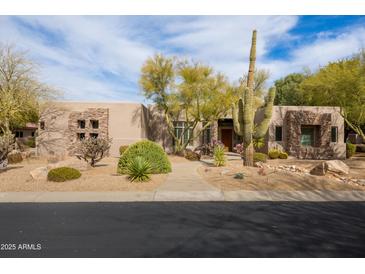 Charming home featuring desert landscaping, a stone facade, and mature trees providing shade and curb appeal at 9626 E Peak View Rd, Scottsdale, AZ 85262