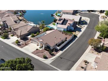 Aerial view of home with solar panels, desert landscaping, near waterfront, and tile roof at 20626 N 55Th Ave, Glendale, AZ 85308