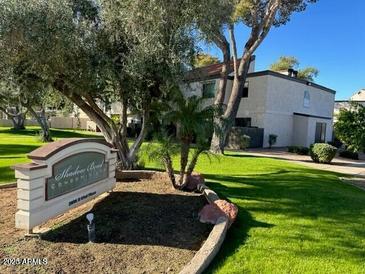 Beautifully landscaped exterior of property showcasing lush green grass, mature trees, and signage at 2938 N 61St Pl # 234, Scottsdale, AZ 85251