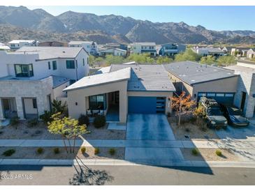 Stunning home showcasing desert landscaping, a blue garage door, and mountain views in the background at 727 E Monte Way, Phoenix, AZ 85042