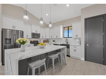 Bright kitchen features a marble countertop island, stainless appliances, and stylish pendant lighting at 3145 S 363Rd Ave, Tonopah, AZ 85354