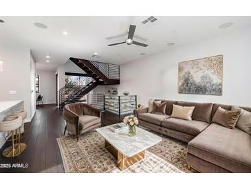 A cozy living room with a plush couch, modern staircase, and stylish decor at 6990 E 6Th St # 1016, Scottsdale, AZ 85251