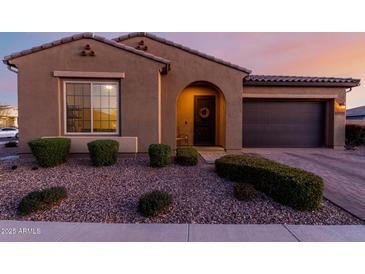 Charming single-story home featuring a desert landscape, arched entry, and a two-car garage at 10309 E Supernova Dr, Mesa, AZ 85212