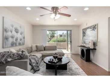 Inviting living room with plush gray sofa, stylish decor, and bright natural light from the sliding glass doors to the patio at 4354 N 82Nd St # 183, Scottsdale, AZ 85251