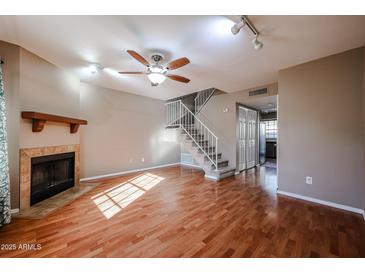 Bright living room featuring a fireplace, staircase, and hardwood floors at 921 W University Dr # 1099, Mesa, AZ 85201