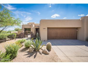 Desert home with a large two car garage and desert landscaping at 11199 E Prospect Point Dr, Scottsdale, AZ 85262