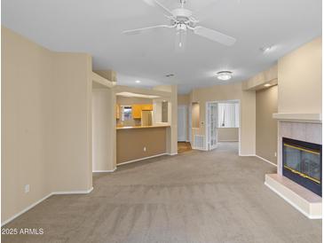 Cozy living room with a fireplace, open to the kitchen area for easy entertaining at 11500 E Cochise Dr # 2067, Scottsdale, AZ 85259