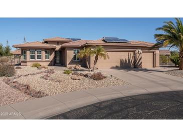 Charming home featuring desert landscaping, solar panels, and a three-car garage at 21730 N Black Bear Lodge Dr, Surprise, AZ 85387