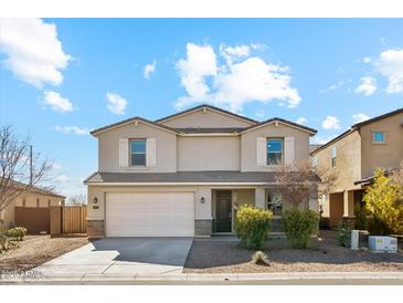 Two-story home featuring a two-car garage, neutral stucco, shuttered windows, and low maintenance landscaping at 37292 N Yellowstone Dr, San Tan Valley, AZ 85140