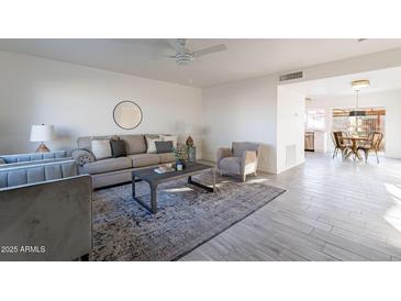 Bright living room features neutral walls, ceiling fan, and gray tile flooring and decor at 4731 N 26Th Ln, Phoenix, AZ 85017
