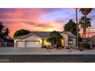 Charming single-story home with a three-car garage and desert landscaping, illuminated by a beautiful sunset at 7144 W Villa Chula --, Glendale, AZ 85310