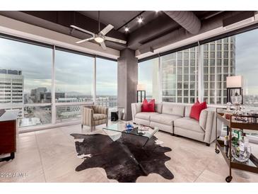 Bright living room with large windows, tile floor, modern furniture, and city views at 1 E Lexington Ave # 1210, Phoenix, AZ 85012