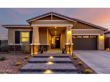 Inviting front exterior features a desert landscape with a covered porch and warm lighting at 12413 W Calle De Baca --, Peoria, AZ 85383