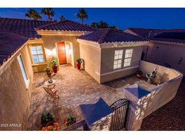 Inviting front courtyard featuring beautiful brick pavers, outdoor seating, and decorative plants at 12936 W Sola Dr, Sun City West, AZ 85375