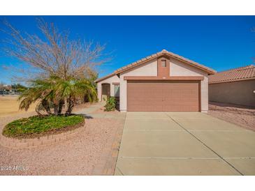 Charming single-story home with a well-manicured yard and a two-car garage at 14946 W Caribbean Ln, Surprise, AZ 85379