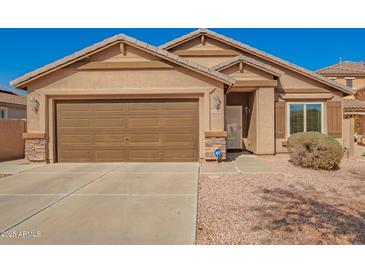 Charming single-story home showcasing a well-kept lawn, desert landscape, and a two-car garage at 16150 W Hope Dr, Surprise, AZ 85379