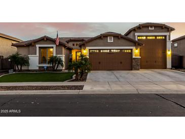 Inviting single-story home featuring a well-manicured lawn, desert landscaping, and attached three-car garage at 17793 W Corrine Dr, Surprise, AZ 85388