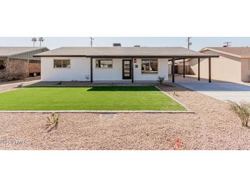 Charming single-story home with a well-manicured lawn and xeriscaped front yard at 2041 W Palo Verde Dr, Phoenix, AZ 85015