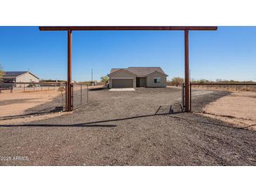 Charming single-story home with a large graveled front yard and a private gated entrance at 29409 N 220Th Ave, Wittmann, AZ 85361