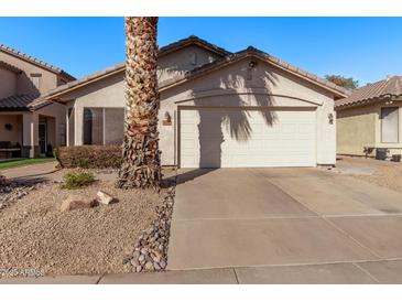 Charming single-story home featuring a two-car garage and desert landscaping at 3232 E Hononegh Dr, Phoenix, AZ 85050