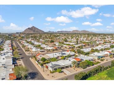 Expansive aerial view of residential area with mountain backdrop under a bright blue sky with scattered clouds at 4622 N 78Th St, Scottsdale, AZ 85251