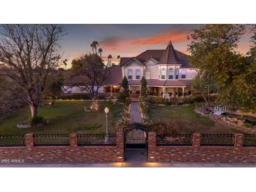 Grand two-story home featuring a turret, manicured lawn, garden path and iron gate at 616 E Carver Rd, Tempe, AZ 85284