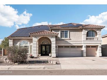 Stunning two-story home features desert landscaping, solar panels, and a three-car garage at 7318 W Paso Trl, Peoria, AZ 85383