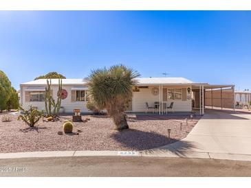 Charming home featuring desert landscaping, covered porch, and a convenient carport at 8233 E Calypso Ave, Mesa, AZ 85208