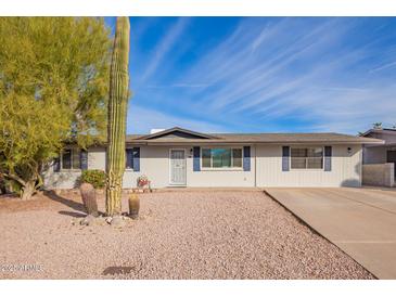 Charming single-story home featuring a desert landscape, blue shutters, and neutral exterior paint at 9134 E Gary Ln, Mesa, AZ 85207