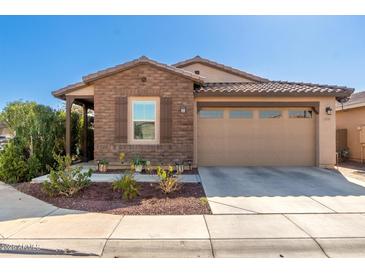 Inviting single-story home featuring a two-car garage, brick accents, and tidy landscaping at 9341 W Willow Bend Ln, Phoenix, AZ 85037