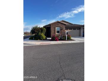 Charming single-story home with brick accents, landscaped front yard, and attached two-car garage at 9341 W Willow Bend Ln, Phoenix, AZ 85037