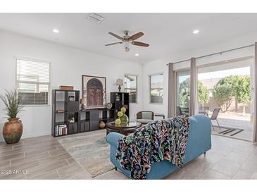 Bright living room featuring stylish decor, tiled floors, and sliding glass doors to the outdoor space at 24385 N 173Rd Ln, Surprise, AZ 85387