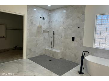 Modern bathroom featuring a glass block window, marble style tile walls, and sleek black matte fixtures at 3010 E Cedar Dr, Chandler, AZ 85249
