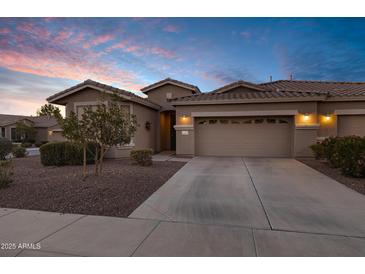 Charming single-Gathering home featuring a desert landscape, tile roof, and a two-car garage against a blue sunset sky at 42072 W Dorsey Dr, Maricopa, AZ 85138