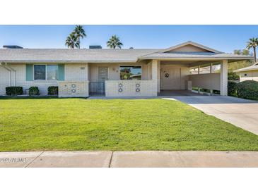 Charming single-story home with a well-maintained lawn and covered porch at 10891 W Clair Dr, Sun City, AZ 85351