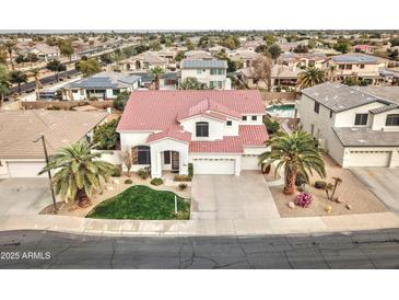 Stunning two-story home featuring a red tile roof, well-manicured lawn, and an attached three-car garage at 14674 W Windsor Ave, Goodyear, AZ 85395