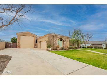 Spacious home with a well-manicured lawn, circular driveway, and three-car garage at 19727 E Julius Rd, Queen Creek, AZ 85142