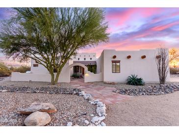 Charming southwestern home featuring a stucco exterior, desert landscaping, and beautiful stone walkway at 19927 W Meadowbrook Ave, Litchfield Park, AZ 85340