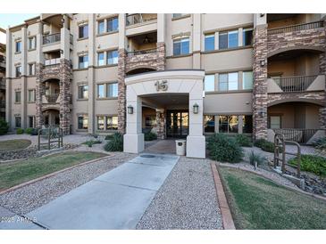 Inviting building entrance with stone accents, a covered walkway and well maintained landscaping at 5350 E Deer Valley Dr # 1275, Phoenix, AZ 85054