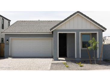 Charming home featuring a gray exterior, two-car garage and an inviting entry way with decorative stone landscaping at 5736 S Daisy Patch Pl, Phoenix, AZ 85040