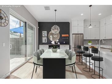 Bright dining area features a modern table, stylish chairs, and access to the outdoor patio at 6301 N 12Th St # 14, Phoenix, AZ 85014