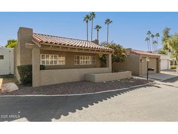 Charming home showcasing a red tile roof, neutral stucco, and tidy desert landscaping at 7345 E Rovey Ave, Scottsdale, AZ 85250