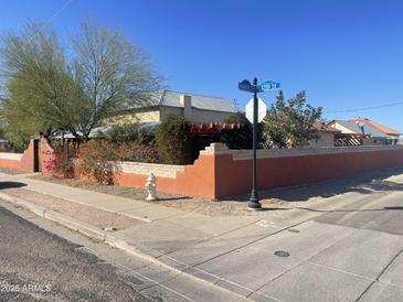 Charming corner lot home featuring a stucco wall, desert landscaping, and a pergola at 94 W 12Th St, Florence, AZ 85132