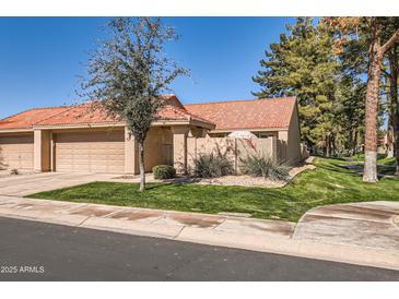 Charming home featuring a red-tiled roof, tan stucco exterior, and a well-maintained lawn at 945 N Pasadena -- # 52, Mesa, AZ 85201