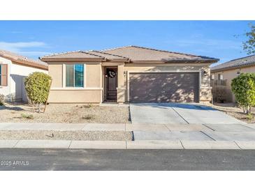 Charming single-story home featuring a two-car garage and low maintenance desert landscaping at 17634 W Via De Luna Dr, Surprise, AZ 85387