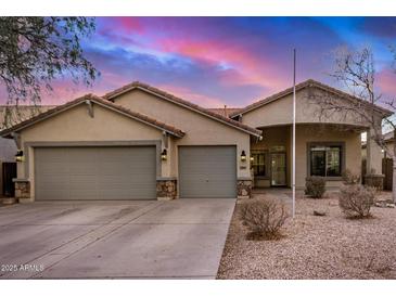 Charming single-story home featuring a three-car garage, neutral stucco, and a beautiful Arizona landscape at 29983 W Fairmount Ave, Buckeye, AZ 85396